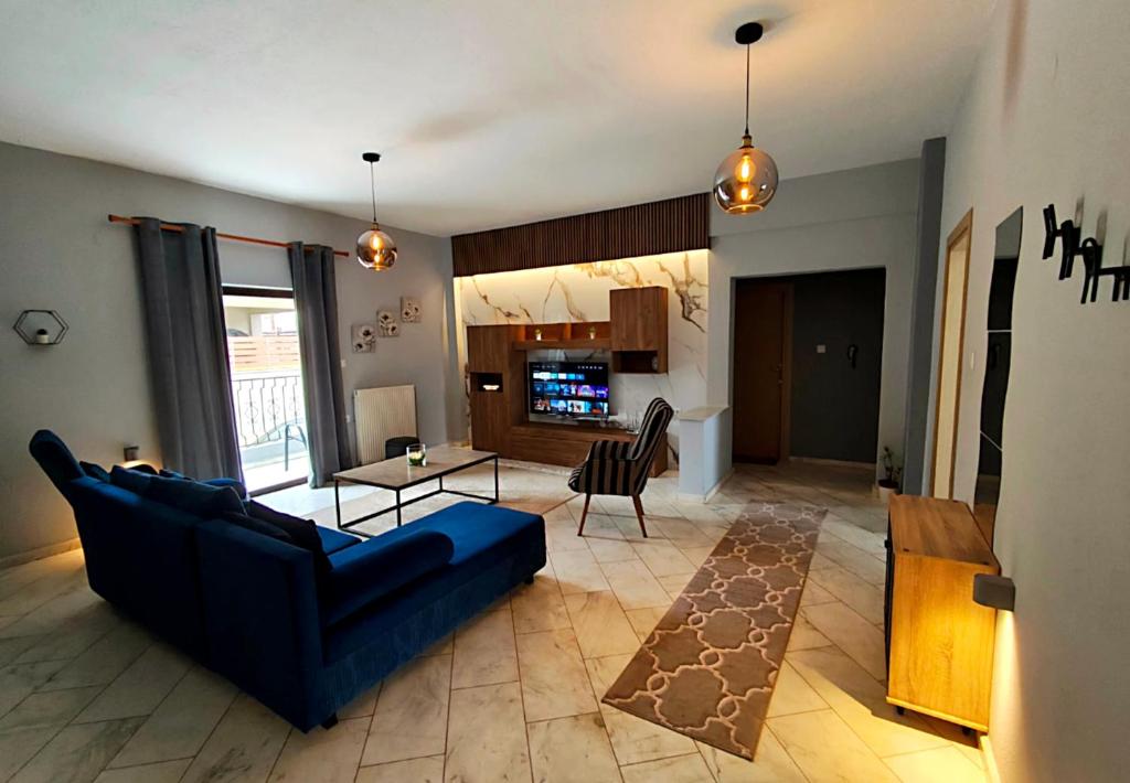 a living room with a blue couch and a table at Meteora House with a view in Kalabaka