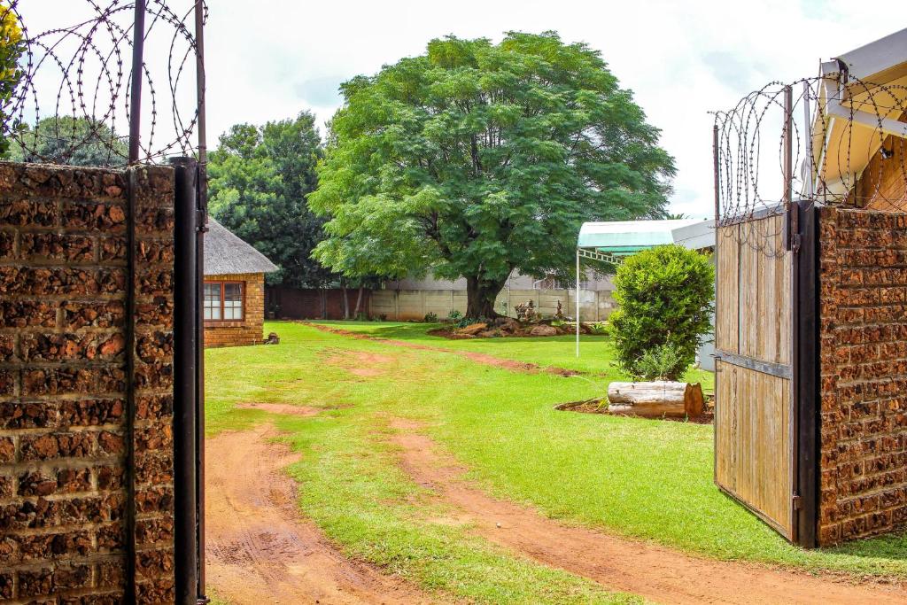 an open gate on a dirt road with a yard at Revitalize in Springs