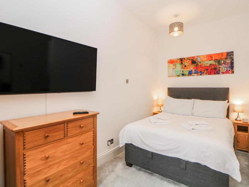 a bedroom with a bed and a flat screen tv at High Tor in Matlock