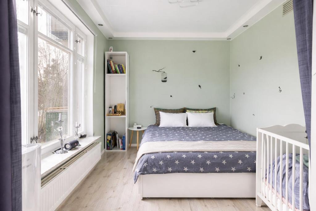 a bedroom with a bed and a large window at Nordic Calm Forest Apartment in Hävla