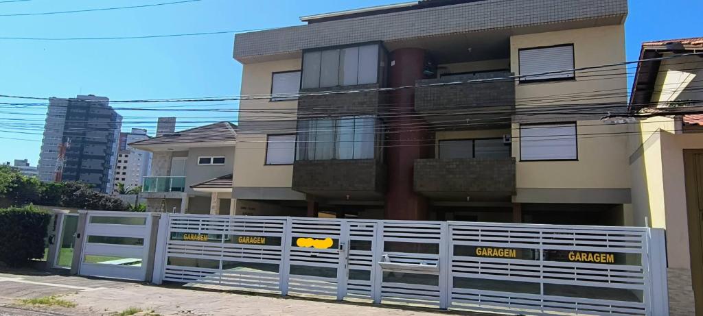 a white fence in front of a building at 203 Barra Refúgio in Tramandaí