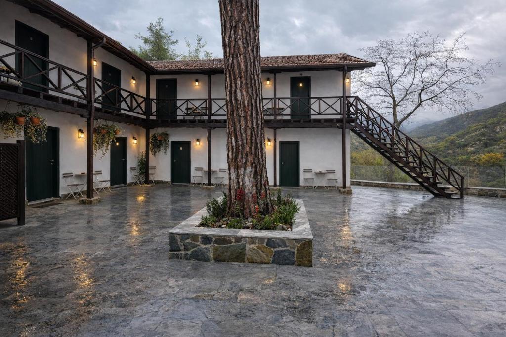 a house with a tree in the middle of a courtyard at Pine View Boutique Hotel Adults Only in Troodos