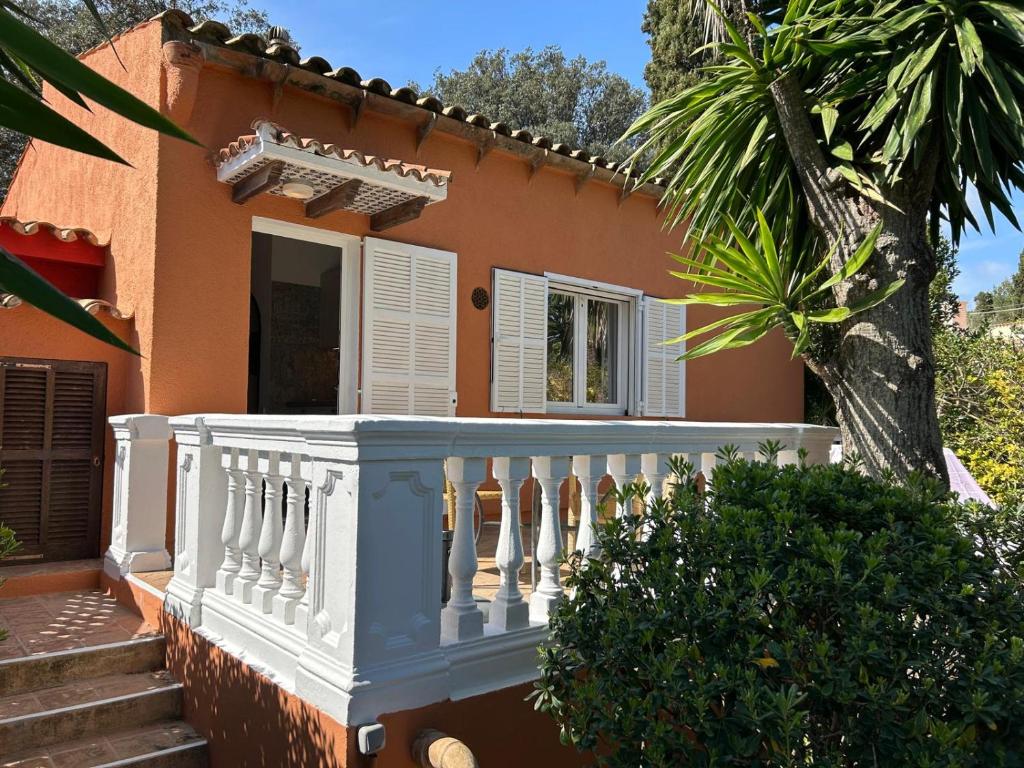 a house with a white balcony and a palm tree at Cas Quinto in Cala Ratjada