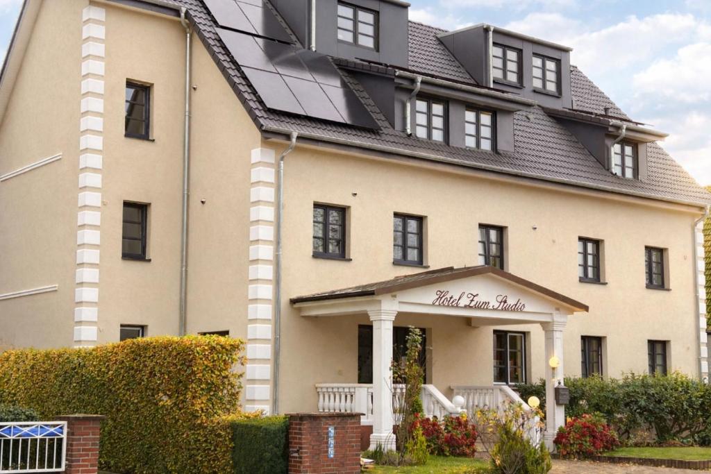 ein großes weißes Haus mit Solardach in der Unterkunft Hotel Zum Studio in Hamburg