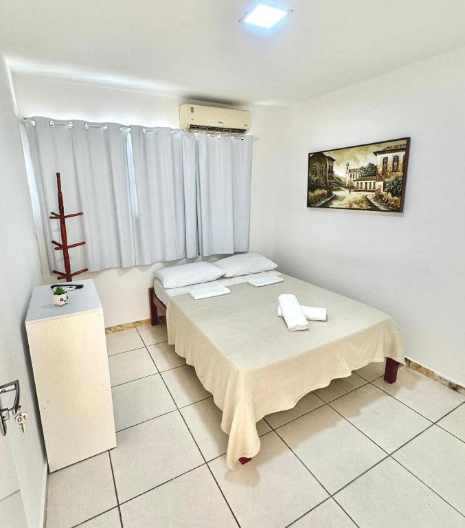 a room with two beds and a window in it at Quarto 01 - Pousada Canaã in Recife