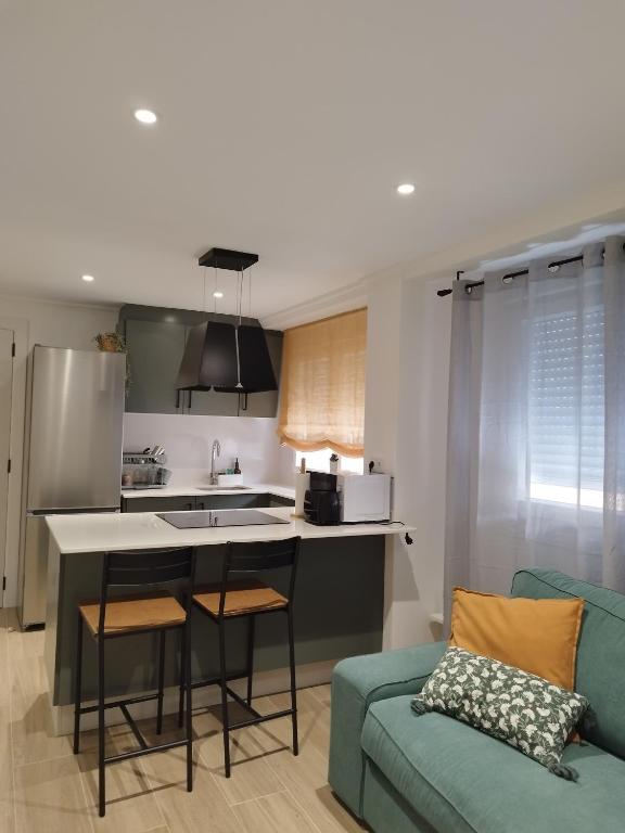 a kitchen and living room with a blue couch at Pretodomar3 in A Coruña
