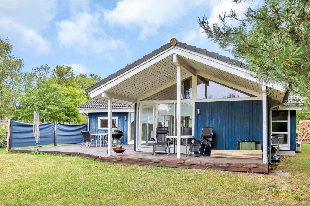 a small blue house with a wooden deck at 14233-Grevinge-Grevinge-Kanalvej-95 in Grevinge