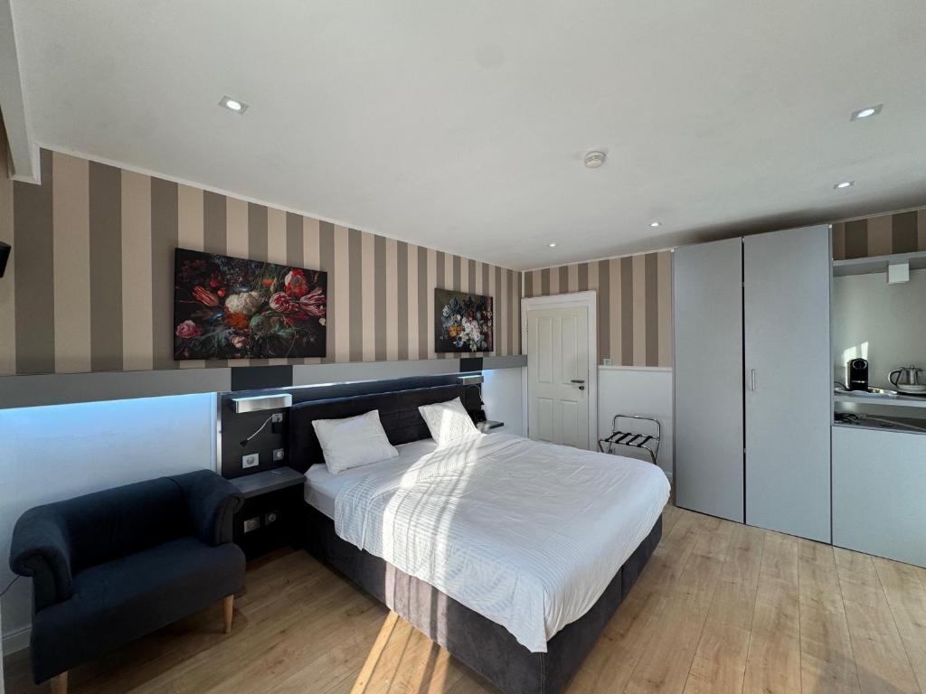 a bedroom with a bed and a chair in it at Résidence des Fleurs in Hombourg-Haut