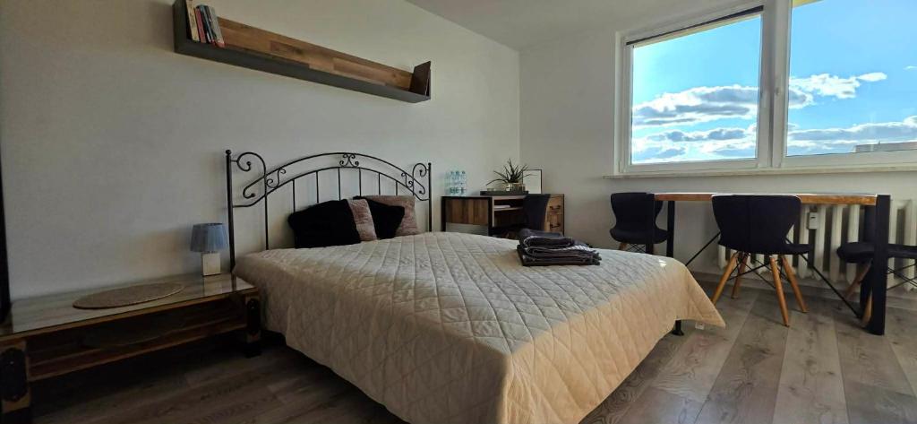 ein Schlafzimmer mit Bett, Schreibtisch und Fenster in der Unterkunft Zakątek w Centrum Suwałk in Suwałki