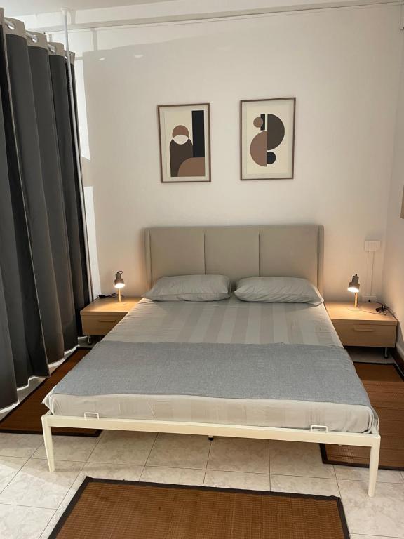 ein Bett in einem Schlafzimmer mit zwei Lampen auf Tischen in der Unterkunft Piccolo Relax in Meina