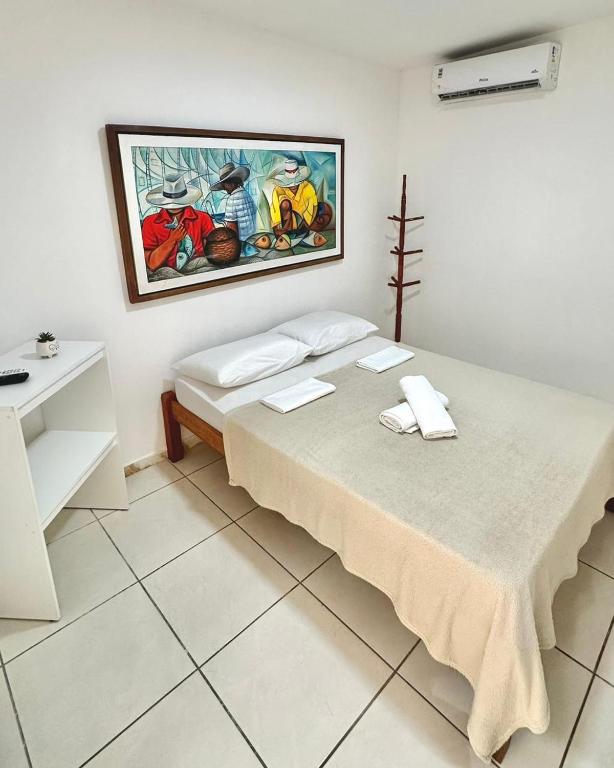 a bedroom with a bed with a painting on the wall at Quarto 03 - Pousada Canaã in Recife