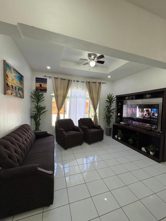 a living room with a couch and a flat screen tv at Casa Herminia in Omoa