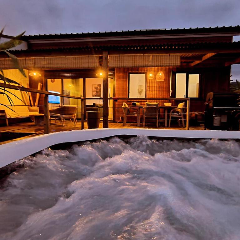 a pool of snow in front of a house at Koa Lodge style Bali avec jacuzzi in Saint-Joseph