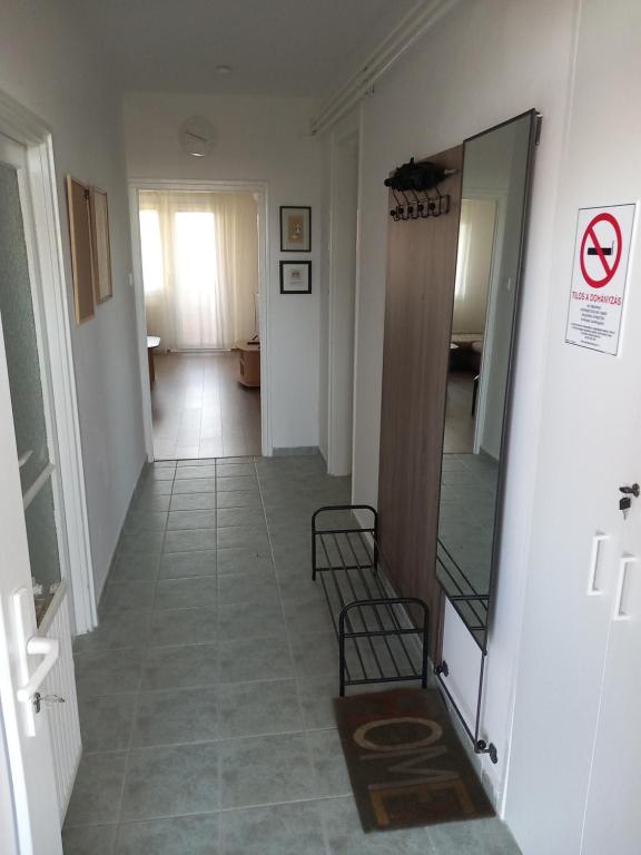a hallway with a mirror and chairs in a room at Fasor Apartman in Kaposvár