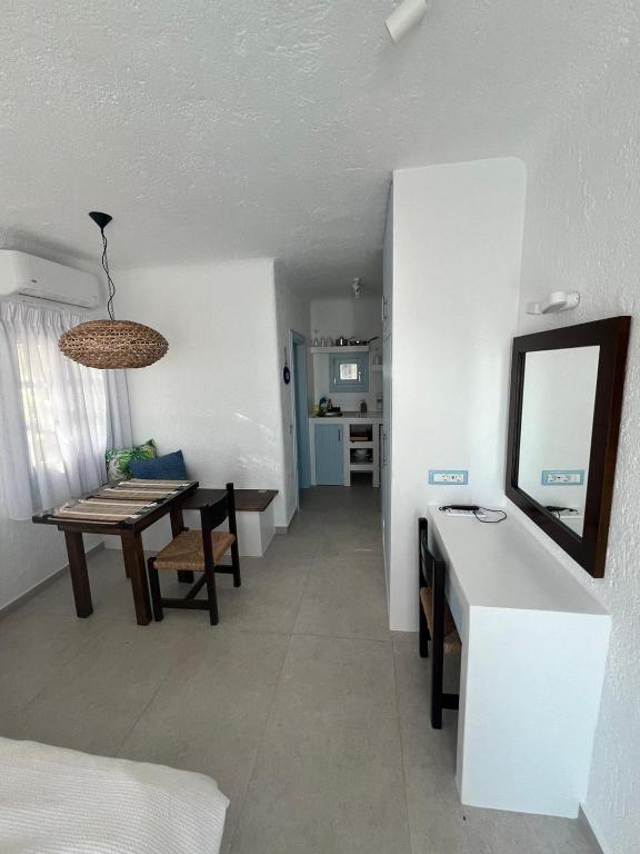 a living room with a table and a dining room at Traditional dream myconian studio in Ornos