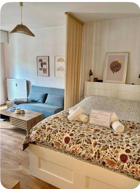 a bedroom with a bed and a blue couch at Downtown Limoges - Secure parking in Limoges