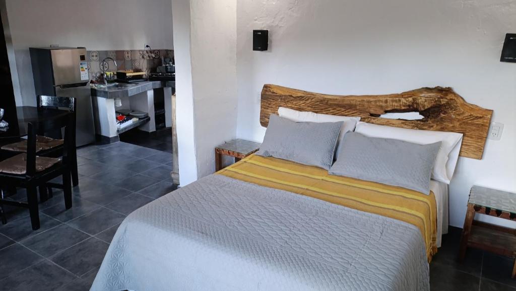a bedroom with a large bed and a kitchen at Cabañas Paqa Paqa in Maimará