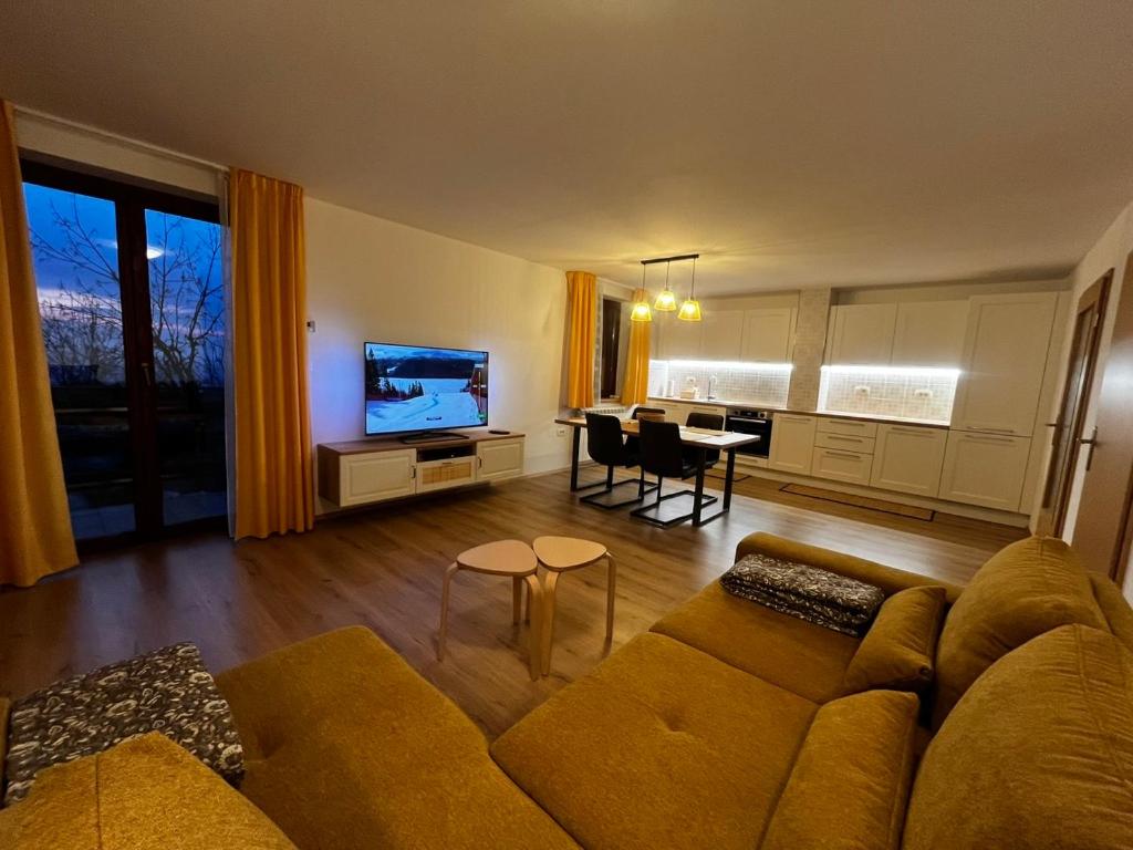 a living room with a couch and a dining room at Rumena hiša in Trnovo