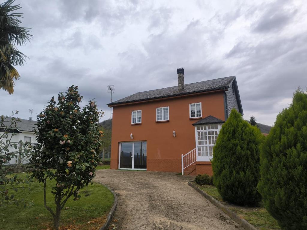 a large orange house with a gravel driveway at Casa Sindo in Teixeira