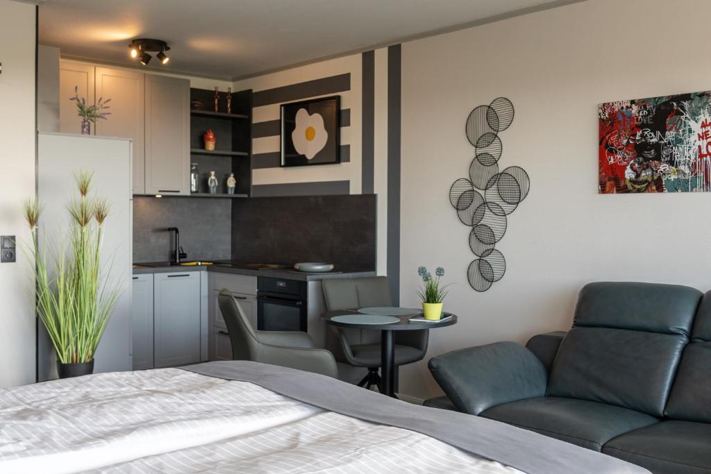 a bedroom with a bed and a table and a kitchen at Studio Relax in Büsum