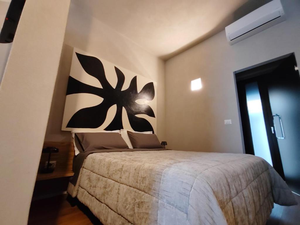 a bedroom with a bed with a black and white headboard at RiDi Home 466- Suite in centro a 5 minuti dal mare in Porto SantʼElpidio