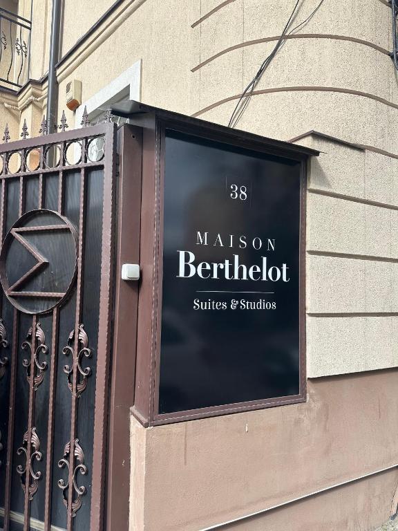 a sign for a restaurant on the side of a building at Maison BERTHELOT in Bucharest