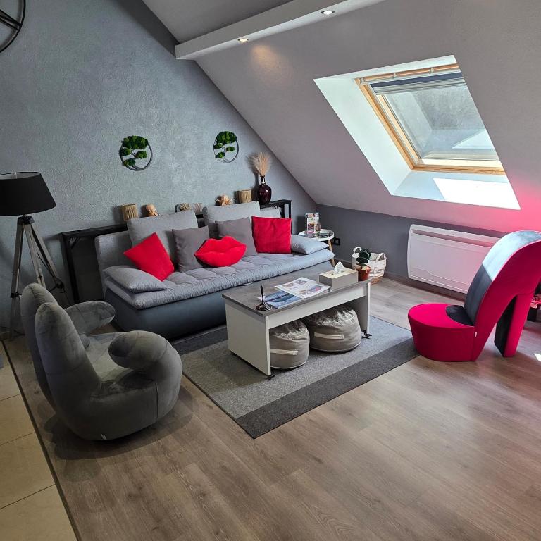 a living room with a gray couch and red pillows at Gîte Vallée de Munster 3 étoiles chez Flavie & Ludo in Muhlbach-sur-Munster