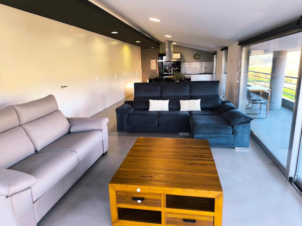a living room with a couch and a coffee table at Atico Deluxe en Vimianzo in Toja