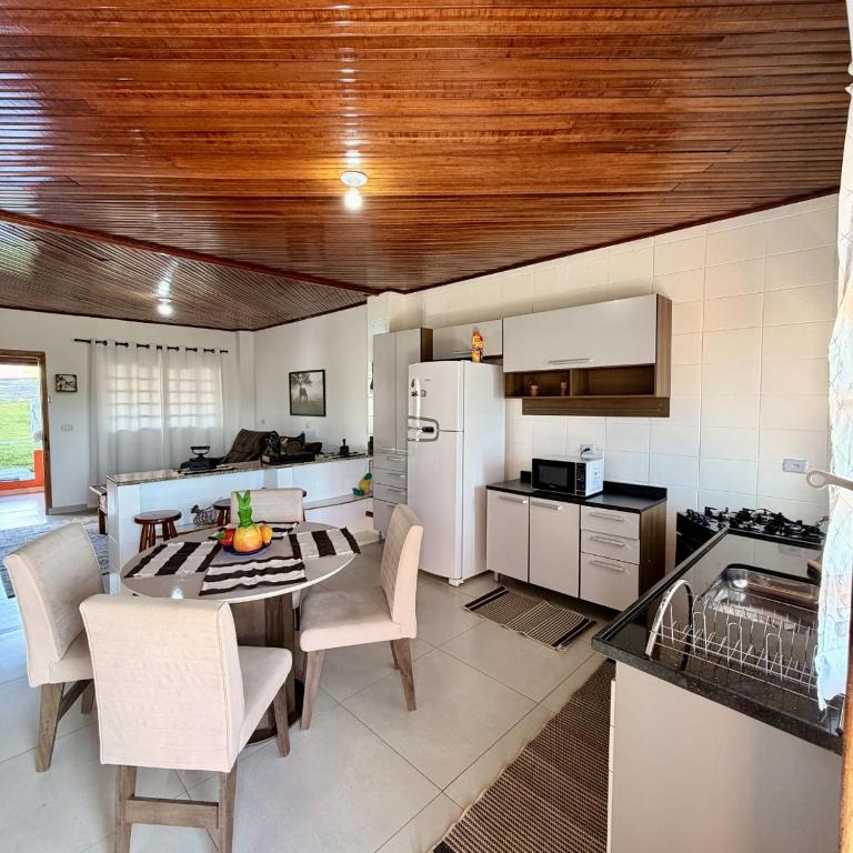 a kitchen with a table and chairs and a refrigerator at Casa 2 - Top Country Ranch in Boituva