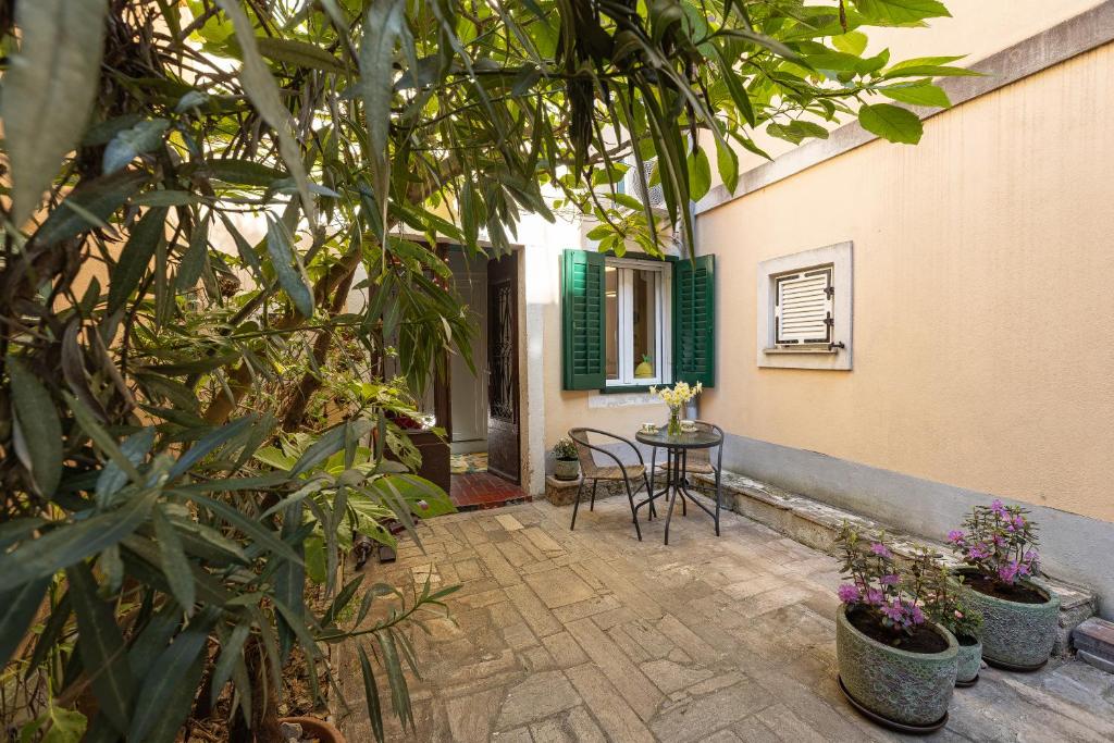 a patio with a table and chairs and plants at Lemon apartment Piran in Piran