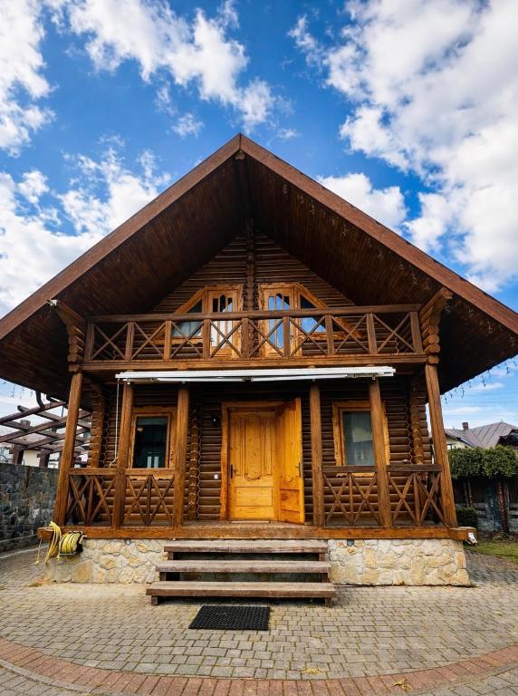 a large wooden house with a roof at Cottage Smerekovyi in Skole