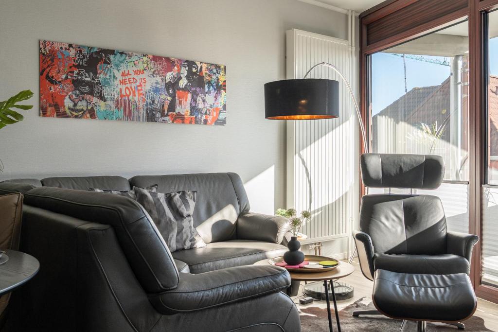 a living room with a couch and two chairs at Apartment MeerZeit in Büsum