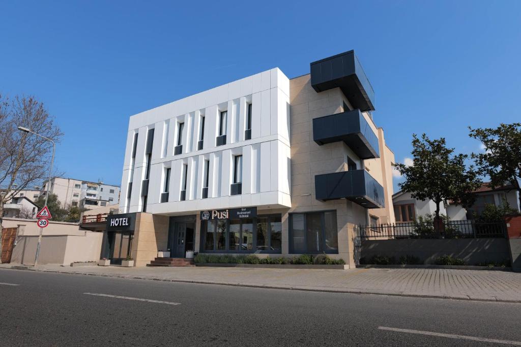 a white building on the side of a street at Hotel Pusi in Sauk