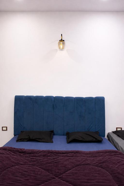a blue bed with a blue headboard in a bedroom at Vrinda vas Homestay in Mathura
