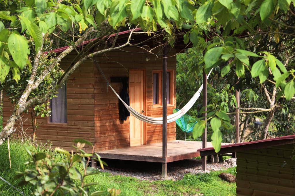 a wooden cabin with a hammock in front of it at Refugio Munay in Florián