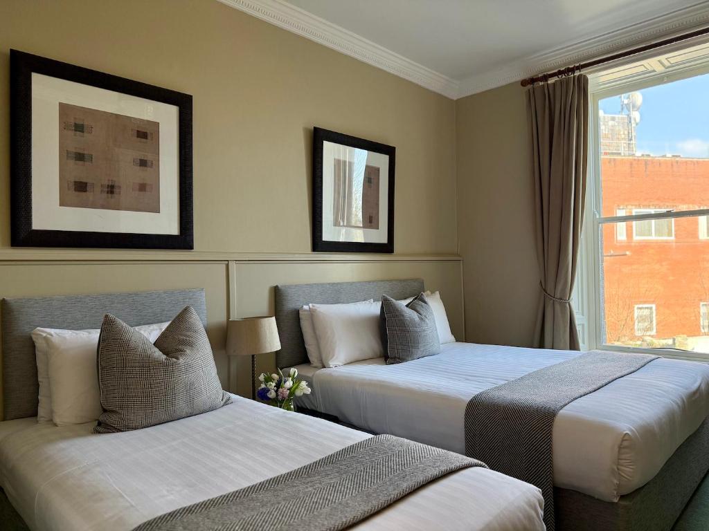 a hotel room with two beds and a window at Berkeley House in Kilkenny