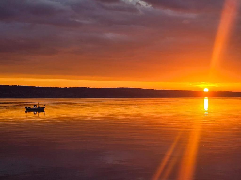a boat on the water with a sunset in the background at Nadalina 9 in Starigrad