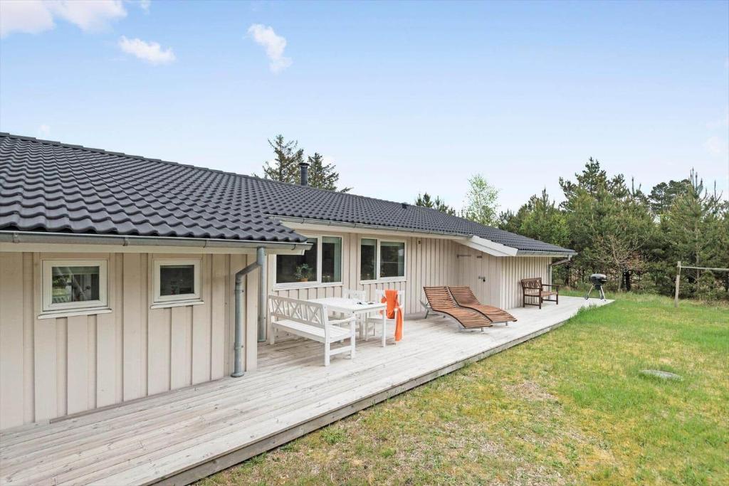 a house with a wooden deck with two chairs at BV235-Oksbol-Kaervej-2 in Oksbøl