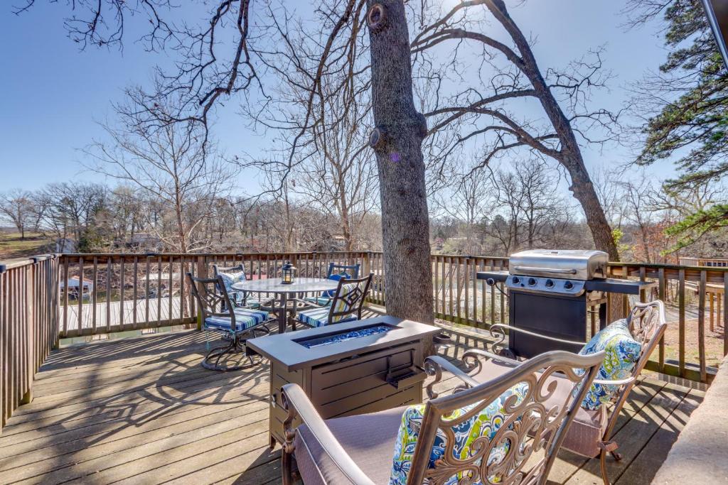 a wooden deck with a grill and tables and chairs at Lakefront Eucha Escape w/ Views & Boat Slip! in Eucha