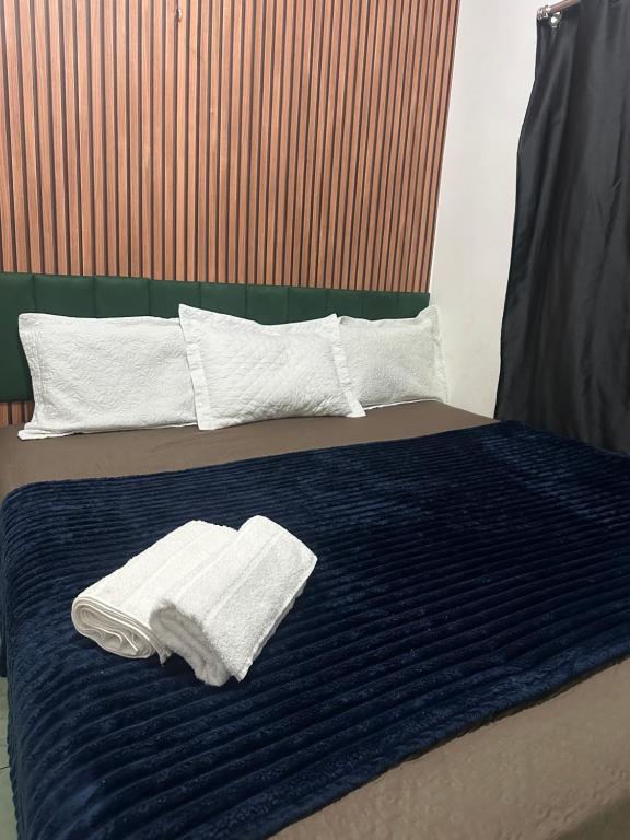 a bed with two towels on top of it at Apto garagem incluso in Marabá