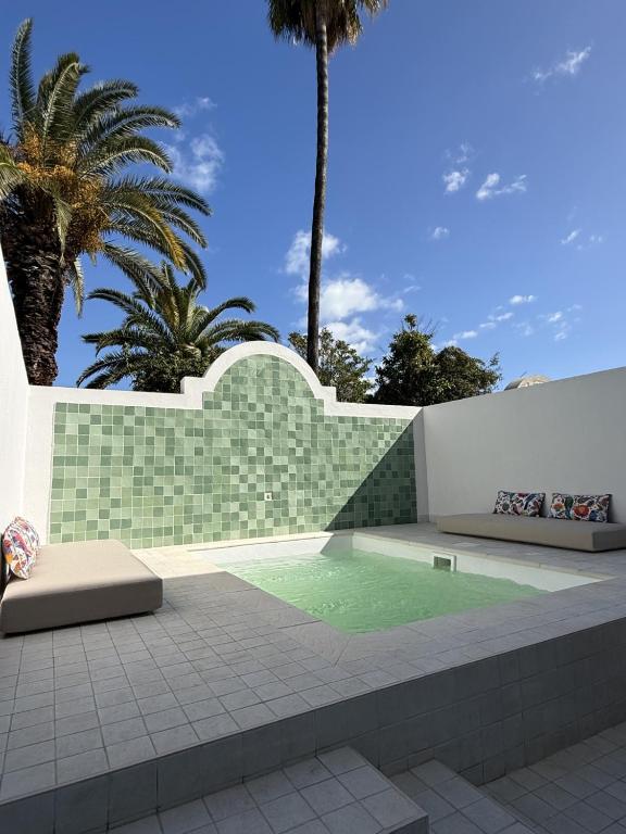 a swimming pool in a courtyard with palm trees at Seabel Alhambra Beach Golf & Spa in Port El Kantaoui
