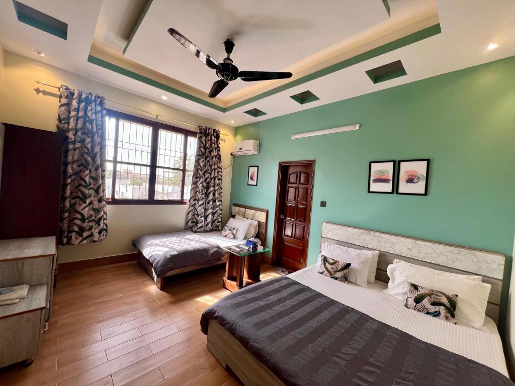 a bedroom with green walls and a bed and a couch at Karachi Inn in Karachi