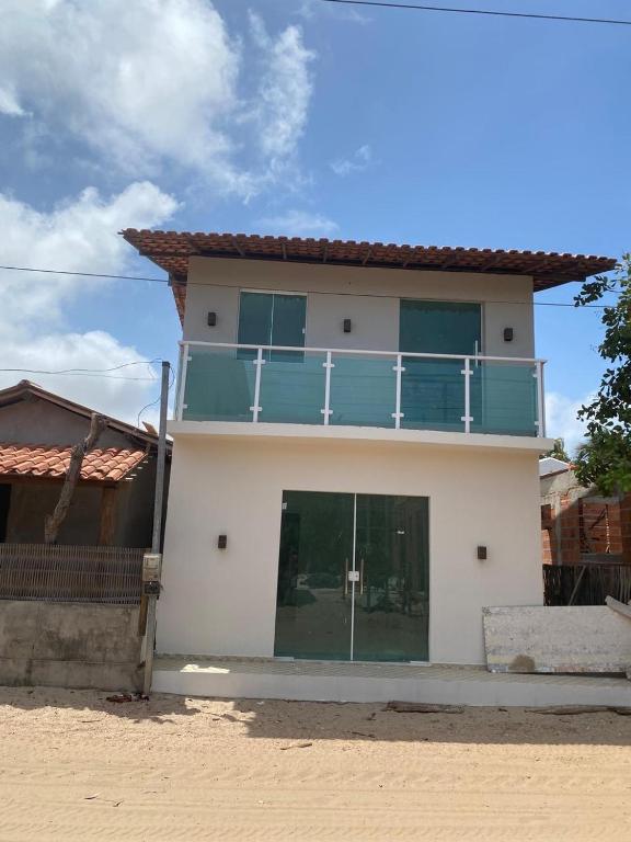 a house with a balcony on top of it at Blessed House Atins in Atins