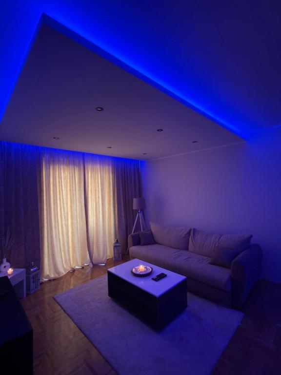 a living room with a couch and a blue light at Grand Line in Sombor
