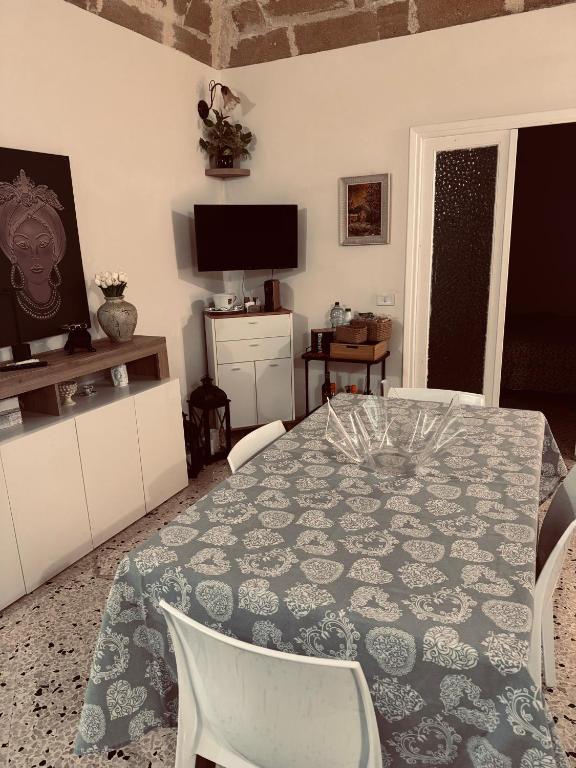 a dining room with a table and chairs and a television at Giovanna Home in Marsala