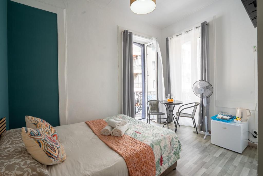 a bedroom with a bed and a table with chairs at Madeirarooms in Funchal
