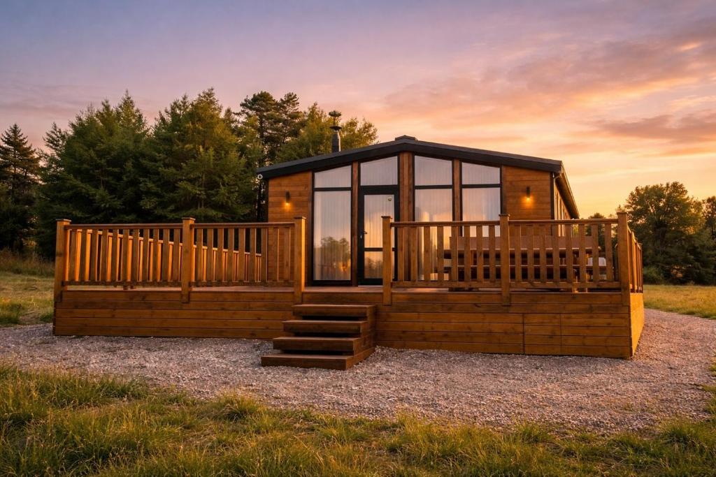 a tiny house with a large deck on gravel at Jaunas Ilgas in Medumi