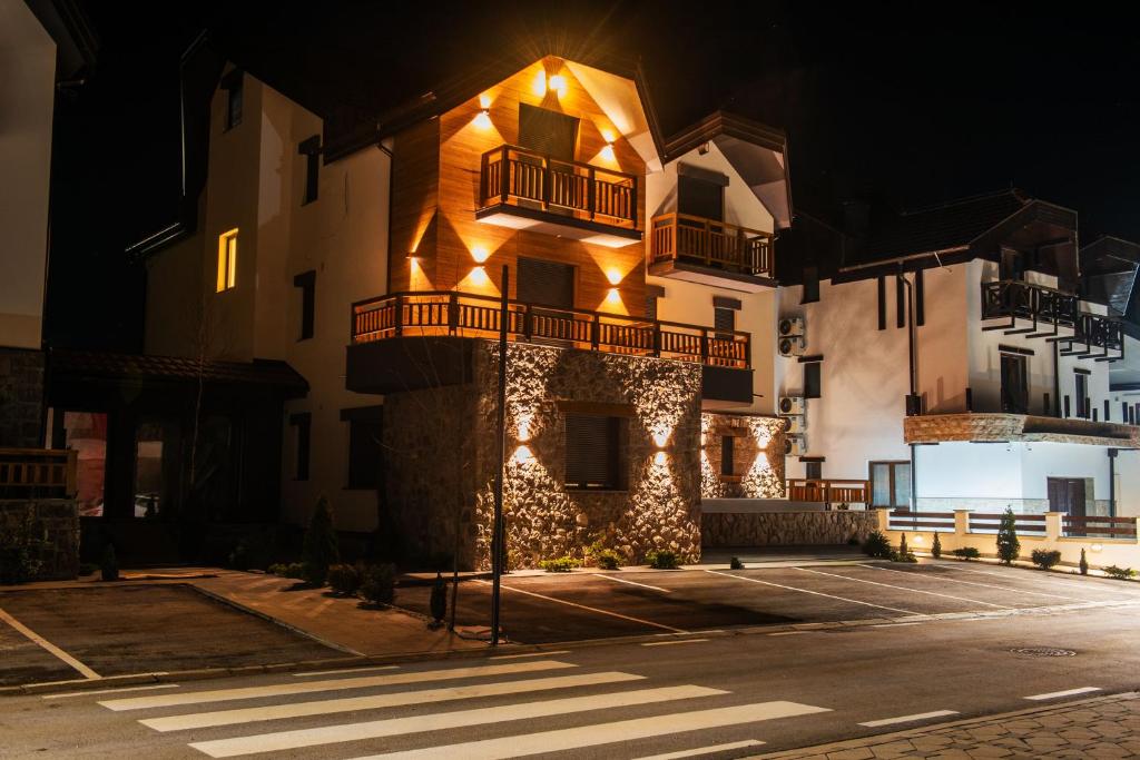 a building with lights on the side of it at night at Apartment Vila Jela in Kolašin