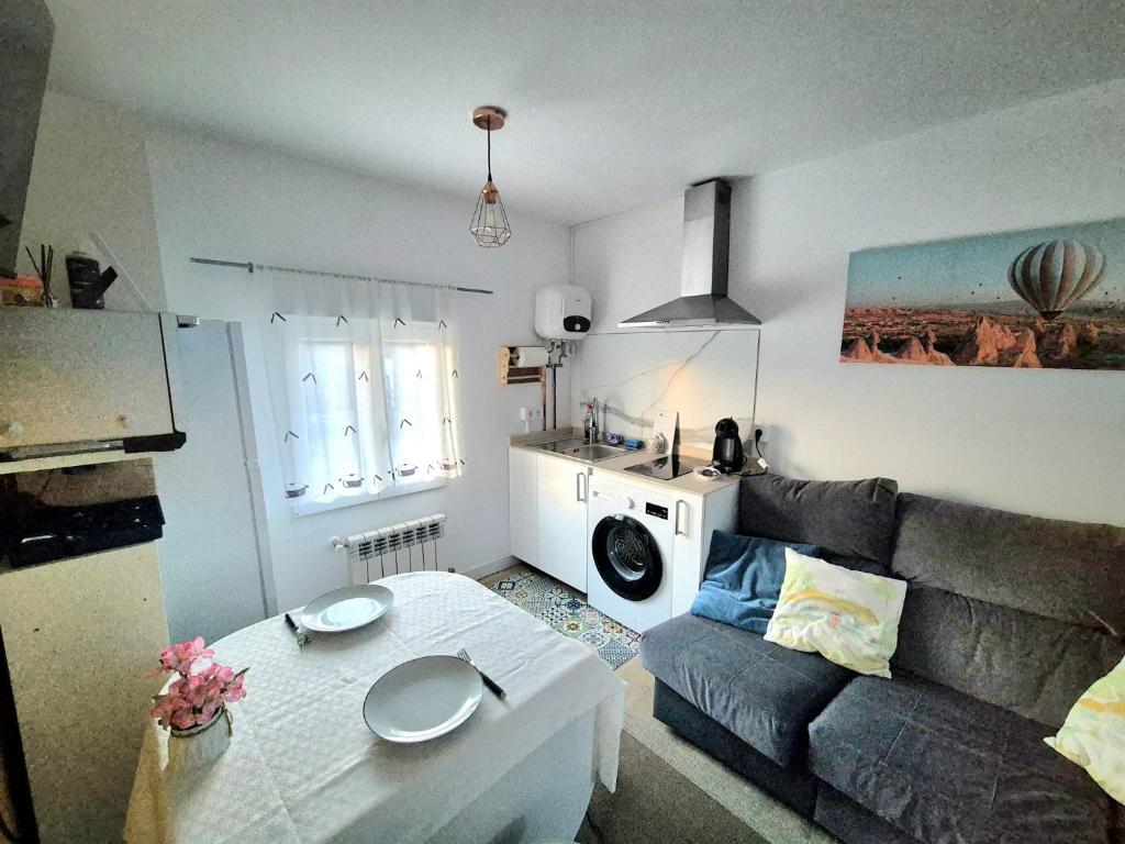 a living room with a couch and a table at Acogedor apartamento de 2 habitaciones, parking & conford in El Astillero