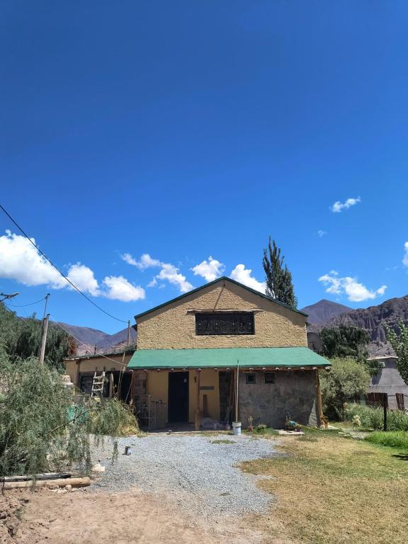 an old building in a field with mountains in the background at Cabaña Padilla in Tilcara